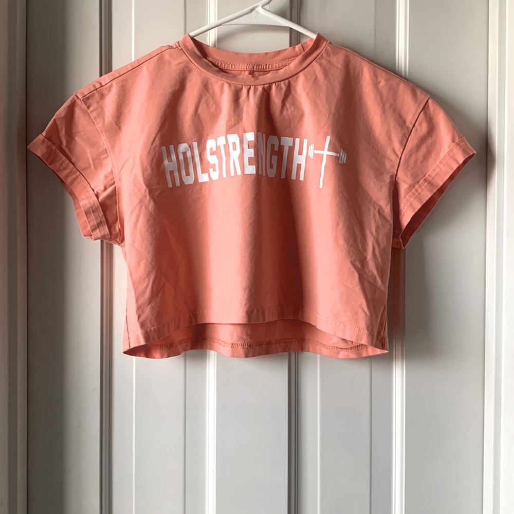 A coral pink, cropped Tee-shirt, size medium from Holstrength.